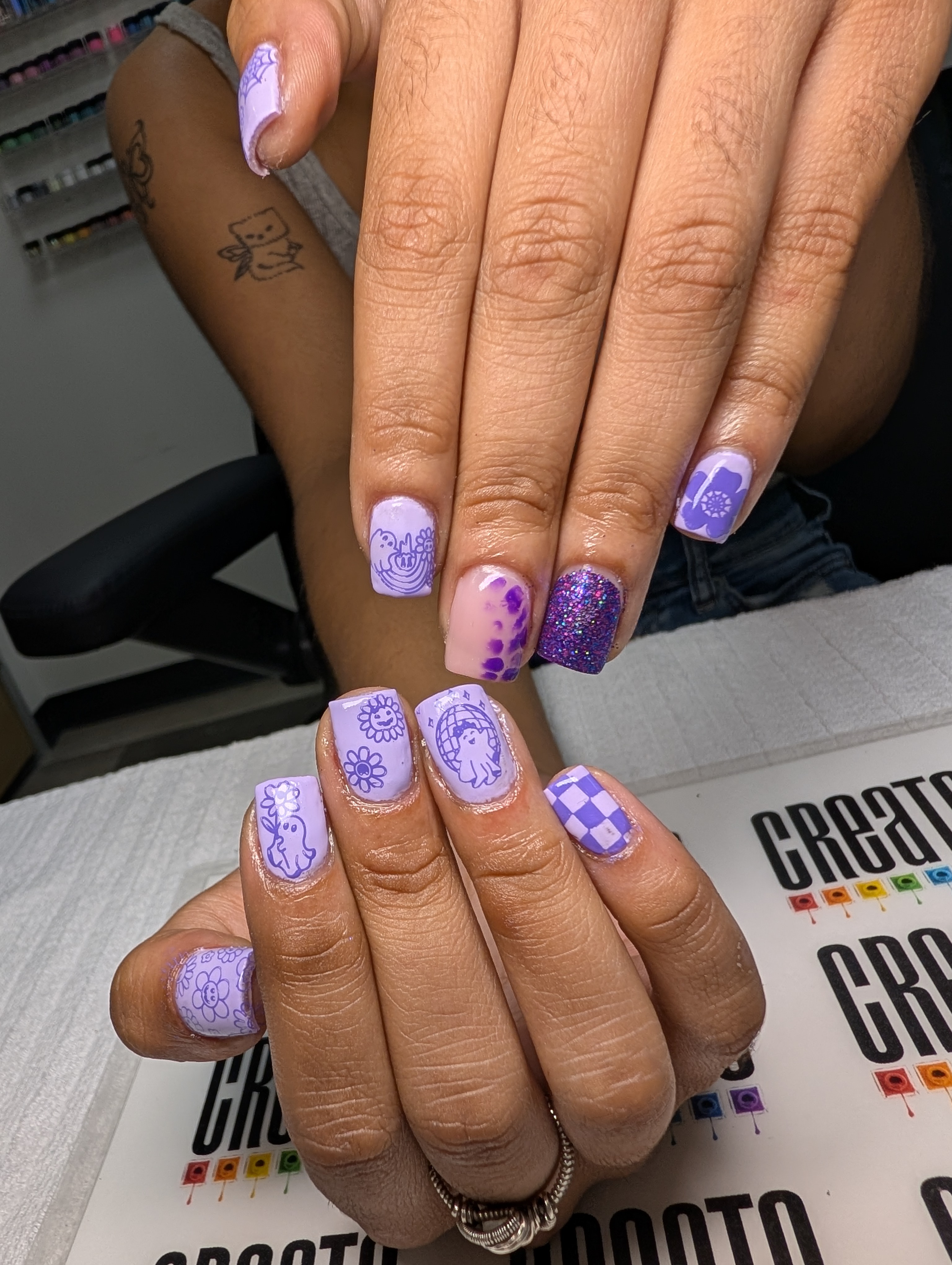 Purple nails with stamps.